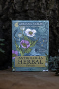 Astrología Herbal Oráculo de Adriana Ayales — caja con ilustraciones botánicas y astrológicas