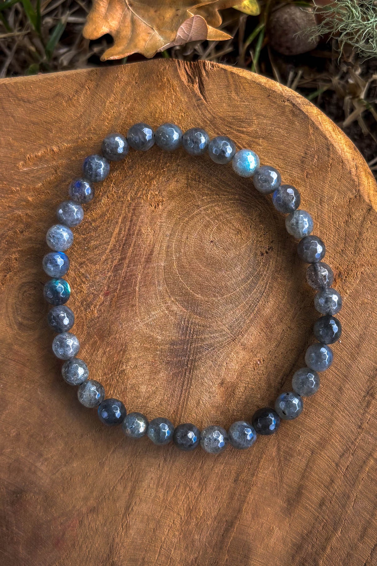 Pulsera de labradorita natural con cuentas facetadas de 6mm con destellos azules sobre madera natural