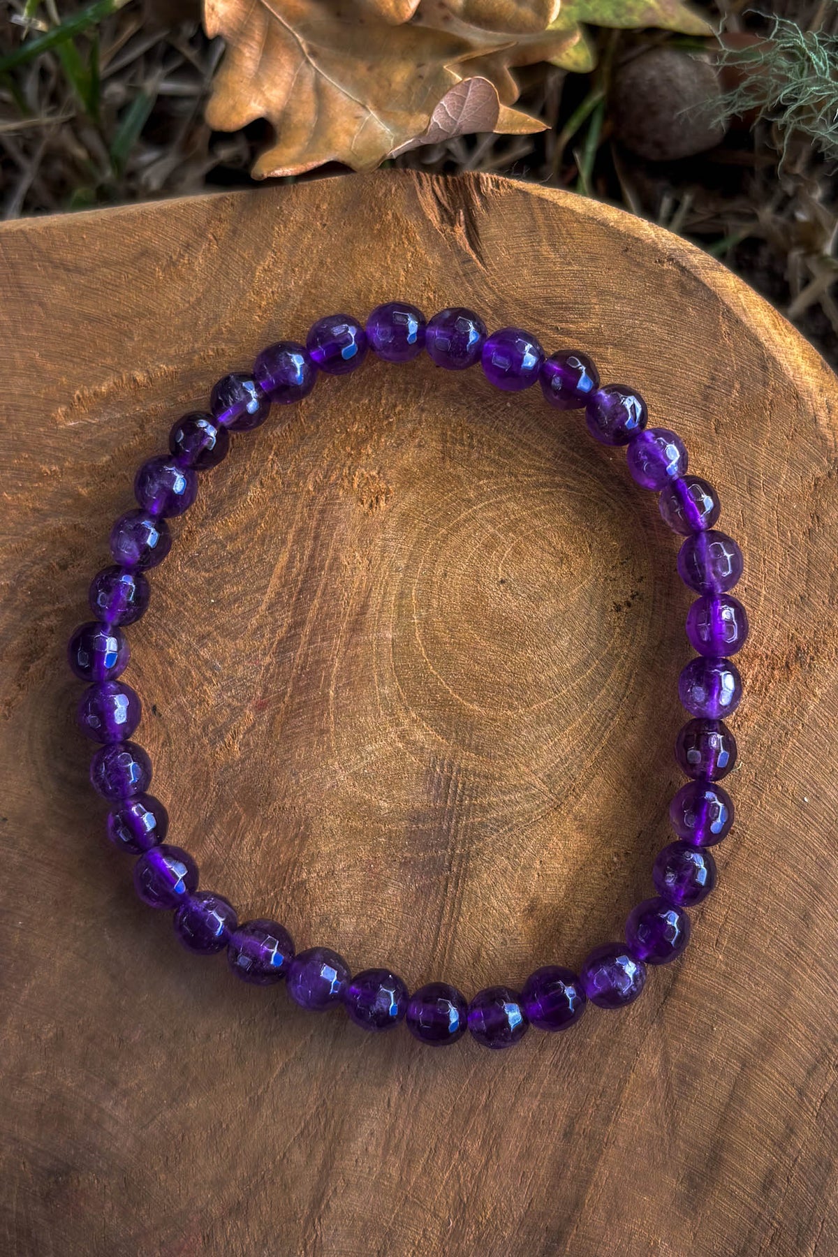 Pulsera de amatista natural con cuentas facetadas de 6mm en tono violeta intenso sobre madera natural