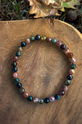 Pulsera de turmalina multicolor natural con cuentas facetadas de 6mm en tonos verde, rosa, negro y miel sobre madera natural