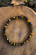 Pulsera de ojo de tigre natural con cuentas facetadas de 6mm en tono dorado miel con destellos sobre madera natural
