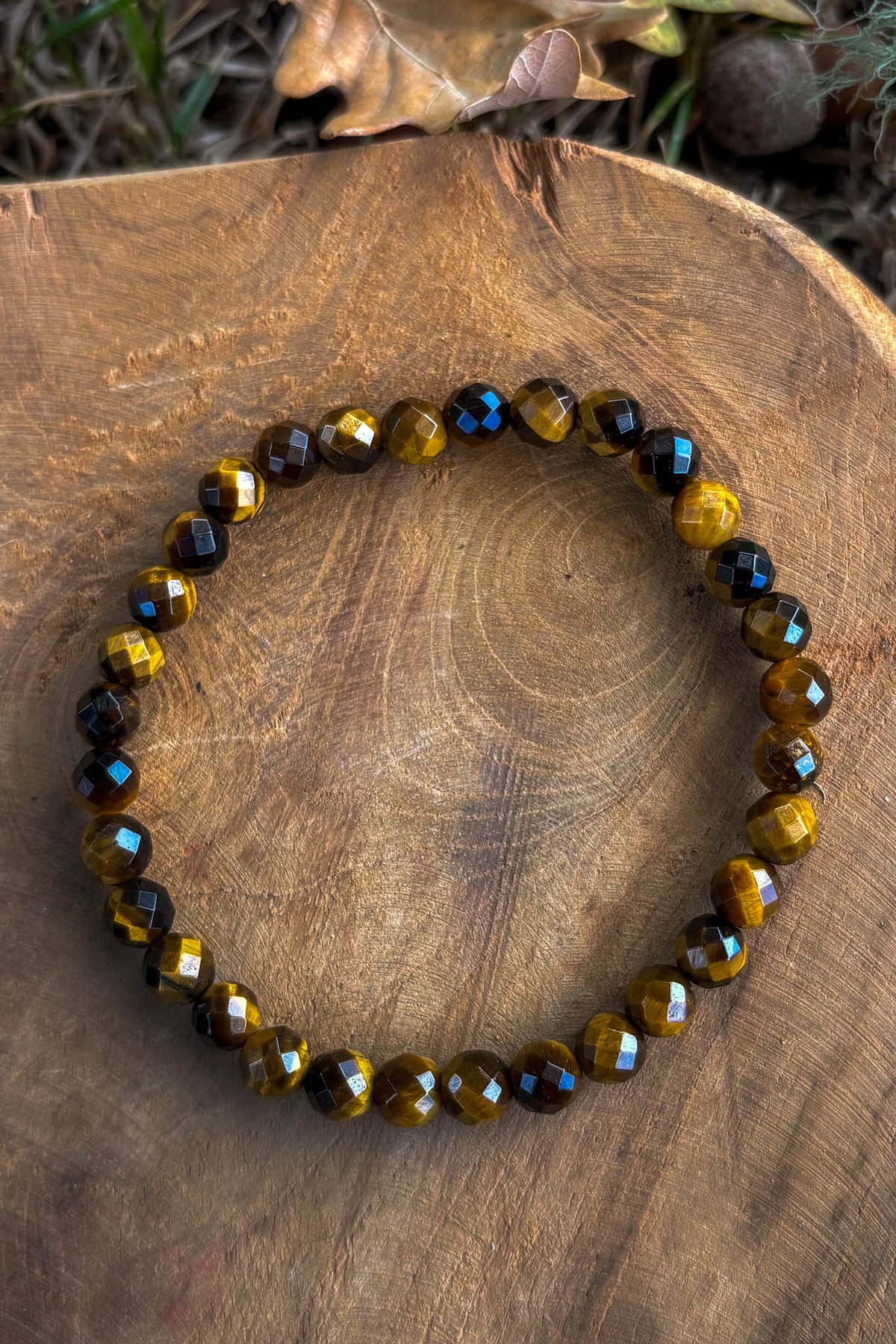 Pulsera de ojo de tigre natural con cuentas facetadas de 6mm en tono dorado miel con destellos sobre madera natural