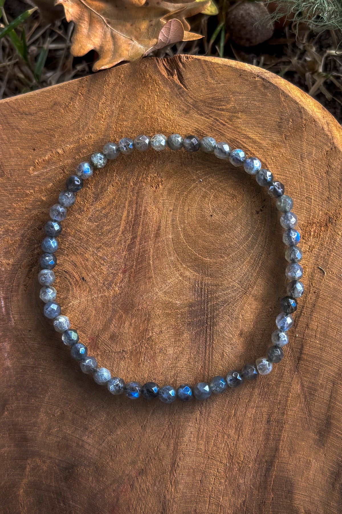 Pulsera de labradorita natural con cuentas facetadas de 4mm con destellos azules sobre madera natural