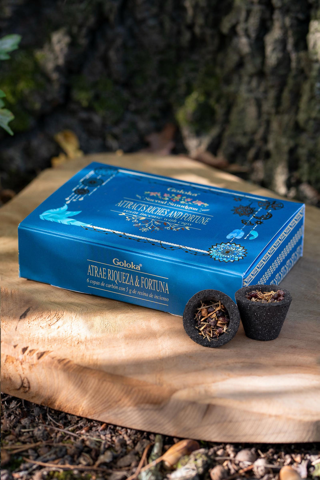 Copas de carbón con resina junto a la caja Atrae Riqueza y Fortuna Goloka