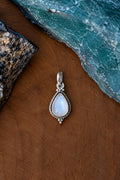 Colgante de plata con piedra luna en forma de gota y borde trenzado