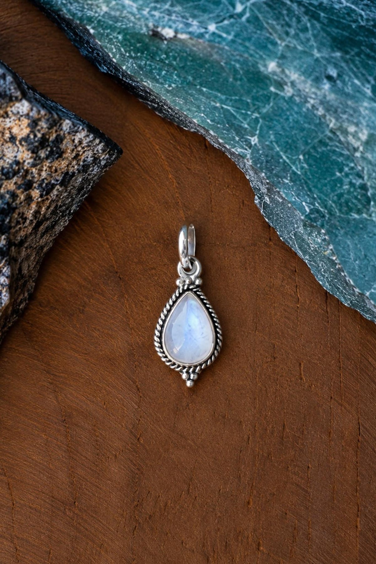 Colgante de plata con piedra luna en forma de gota y borde trenzado