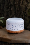 Difusor blanco con luna y estrellas caladas y base con acabado efecto madera