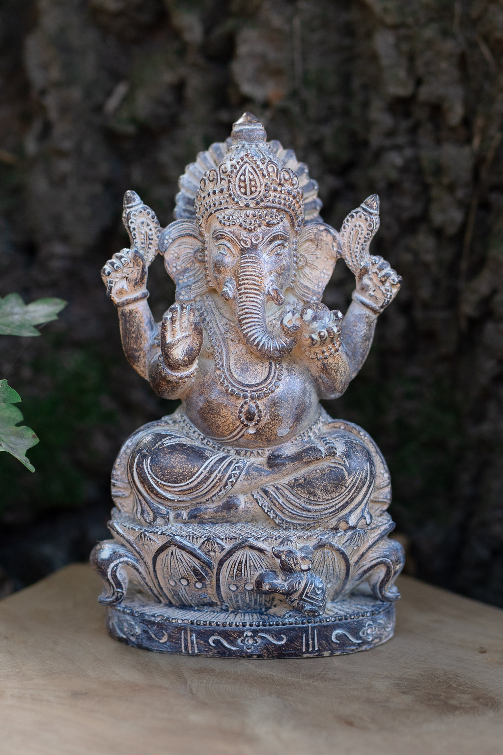 Figura de Ganesha sentada en tonos plateados, con corona y base ornamentada