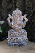 Figura de Ganesha sentada en tonos plateados, con corona y base ornamentada