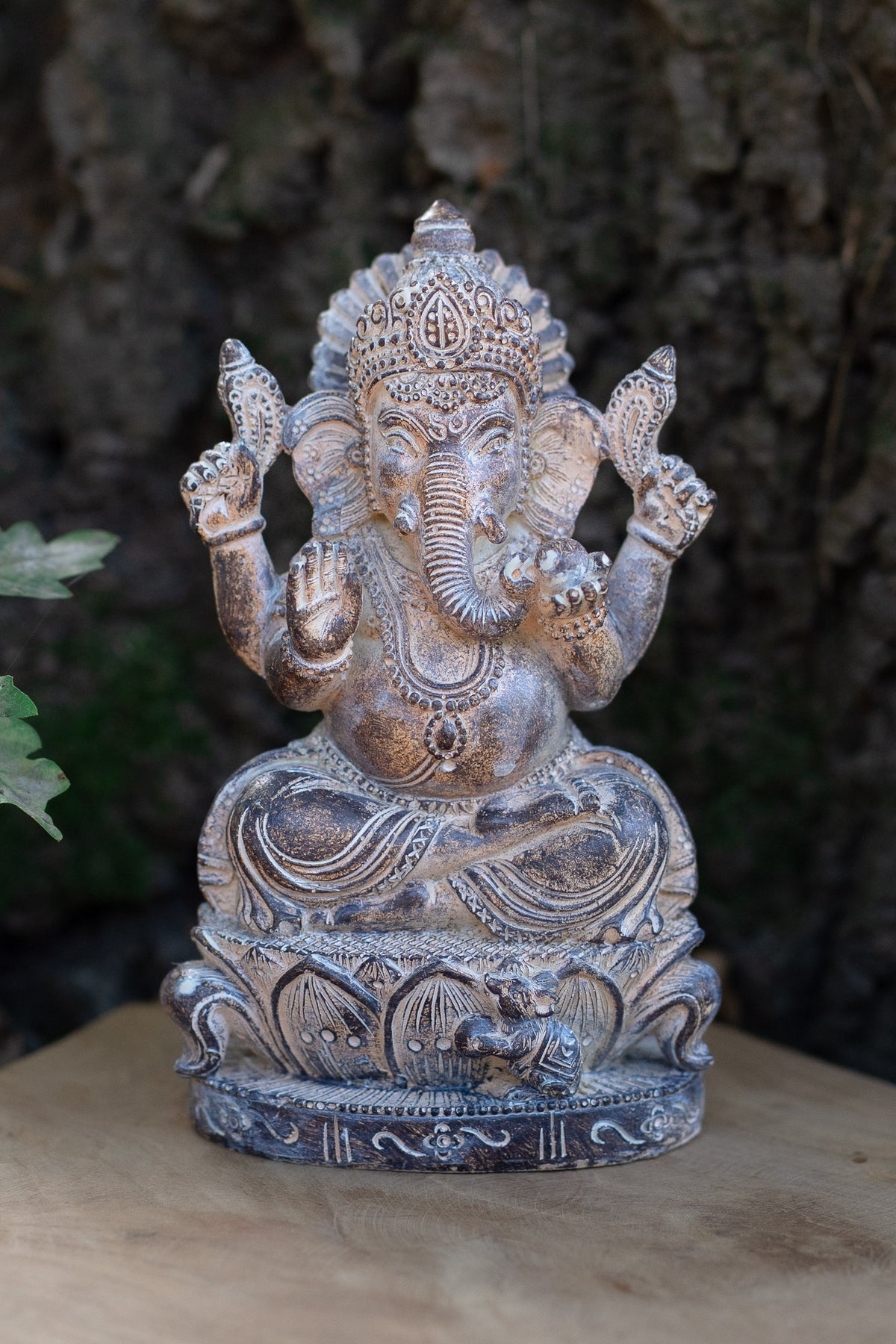 Figura de Ganesha sentada en tonos plateados, con corona y base ornamentada
