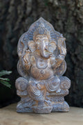 Figura de Ganesha en tonos plateados sentada en un trono con respaldo ornamentado
