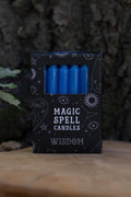 Caja negra Magic Spell Candles Wisdom con velas azules y símbolos celestes.