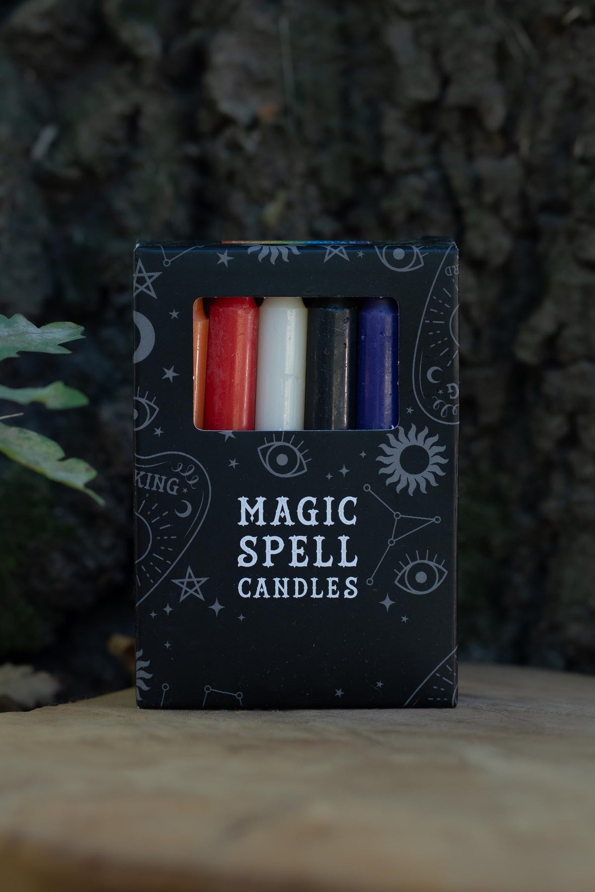 Caja negra Magic Spell Candles con velas de distintos colores y símbolos celestes.