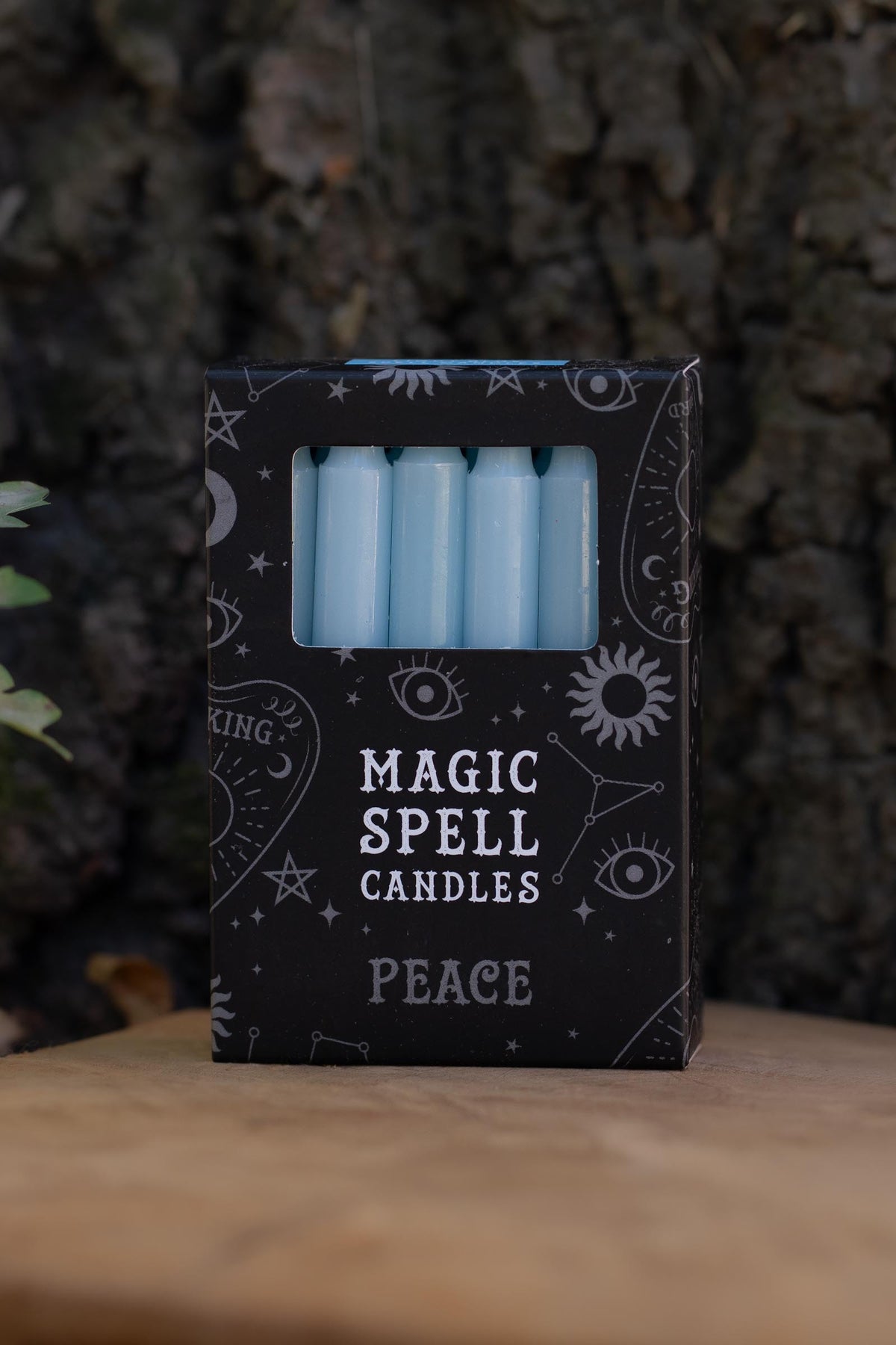 Caja negra Magic Spell Candles Peace con velas azul claro y símbolos celestes.