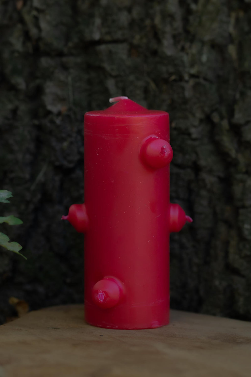 Velón rojo de siete mechas de Las Velas de Mariano con forma cilíndrica y salientes laterales.