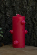 Velón rojo de siete mechas de Las Velas de Mariano con forma cilíndrica y salientes laterales.