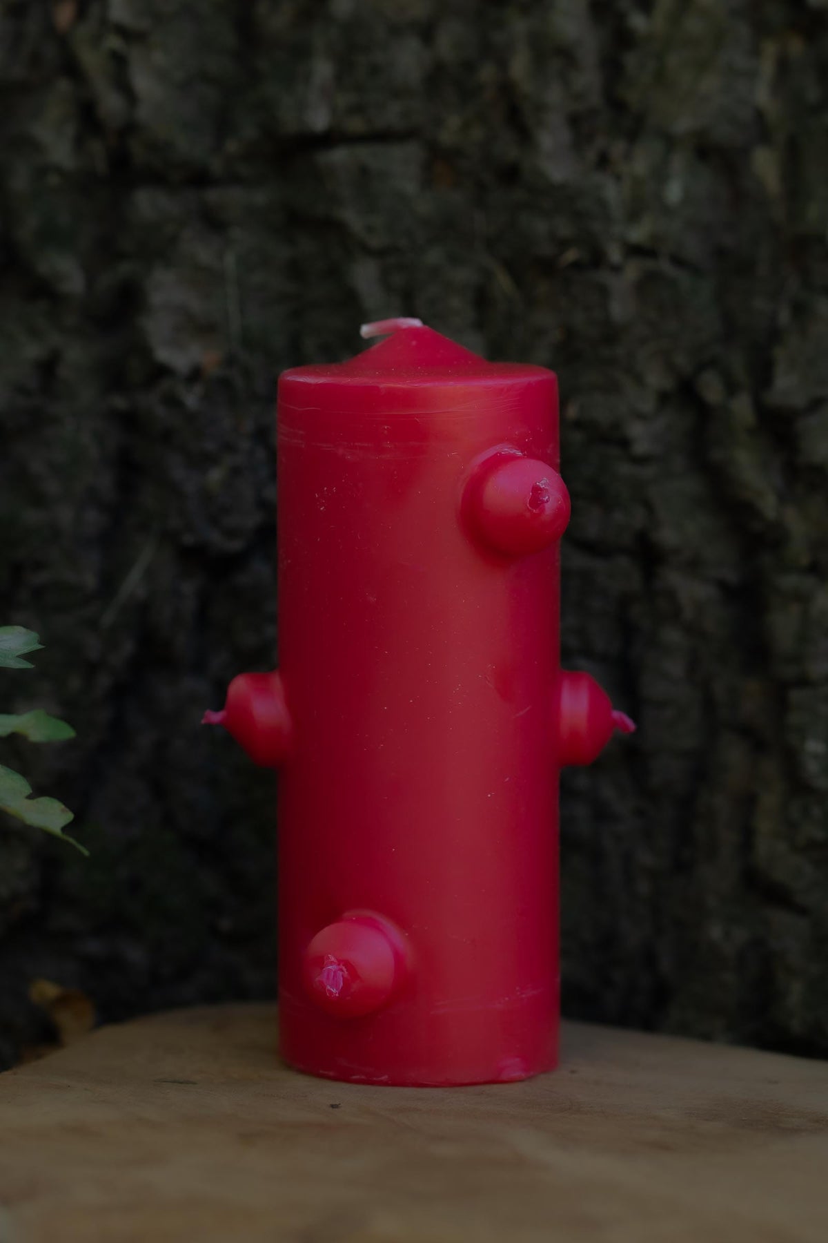 Velón rojo de siete mechas de Las Velas de Mariano con forma cilíndrica y salientes laterales.