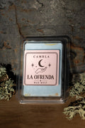 La Ofrenda Wax Melt de Cambla en packaging transparente azul celeste sobre madera con musgo